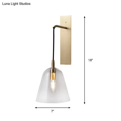 A retro style brass wall light with frosted glass bell-shaped shade and exposed e14 bulb base bedroom sconce