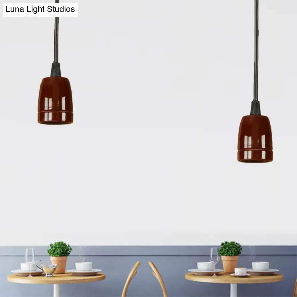 Two decorbites™ retro style pendant lights with glossy black red ceramic shades and adjustable black cords hanging from ceiling