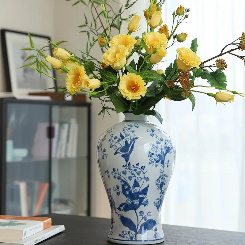 Retro yellow and white porcelain vase featuring decorbites blue white floral patterns holding yellow roses for living room decor