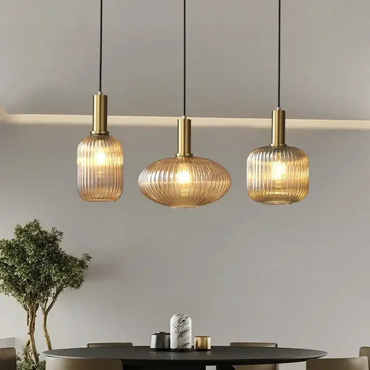 Three elegant ribbed amber glass pendant lights with brass finish enhance modern dining room decorbites colorful glass