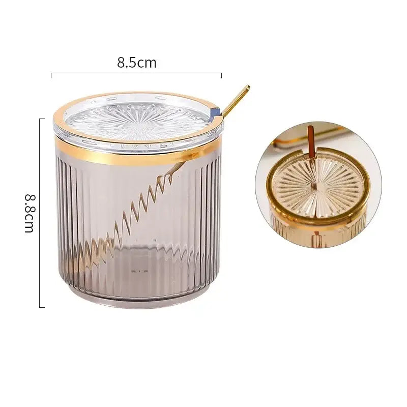A sleek translucent gray acrylic seasoning jar with vertical ridges and gold sunburst lid in decorbites seasoning jar set