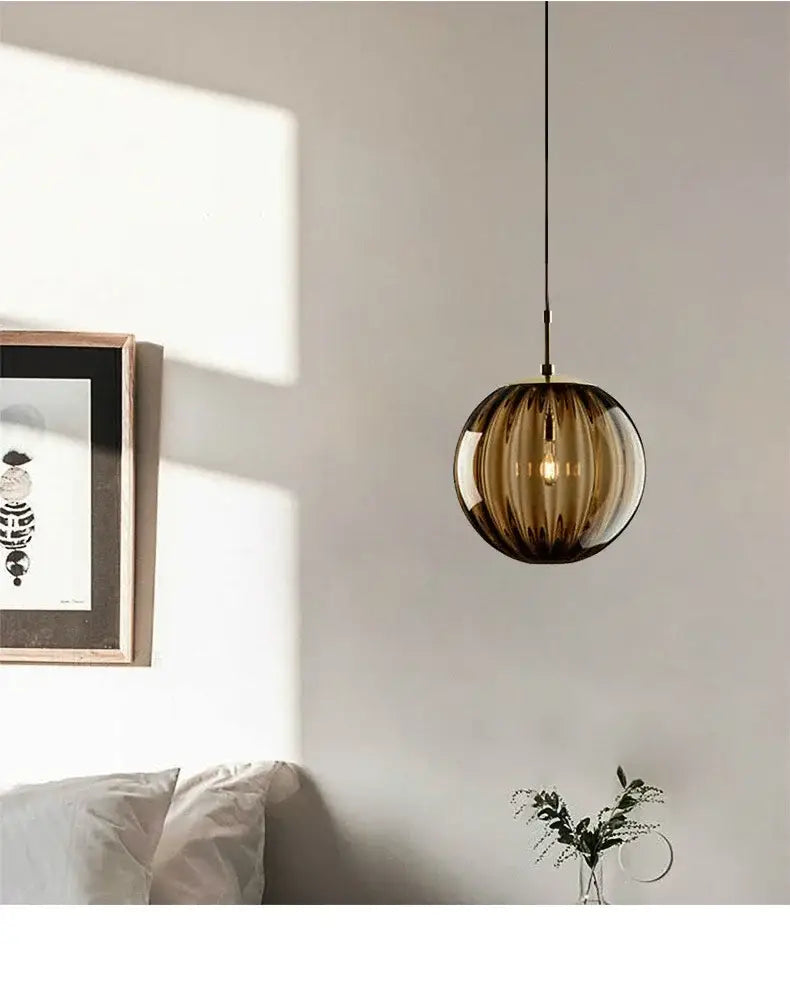 A spherical amber ribbed glass pendant light with warm glow from decorbites glass ball pendant lamp set for living room