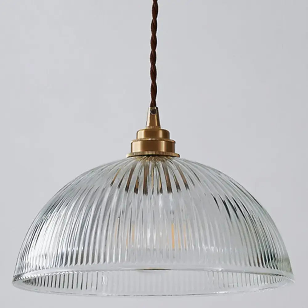 Clear ribbed glass pendant light with brass fixture and twisted brown cord for dining room by DecorBites