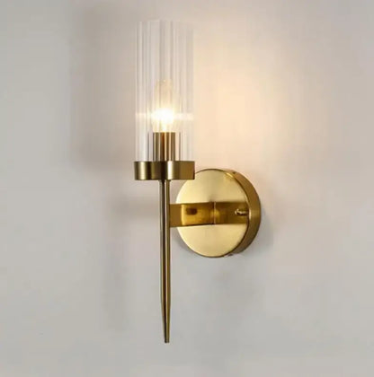 Gold-toned wall lights with a clear vertically ribbed glass shade and slender metallic stem by decorbites gold led for bedroom