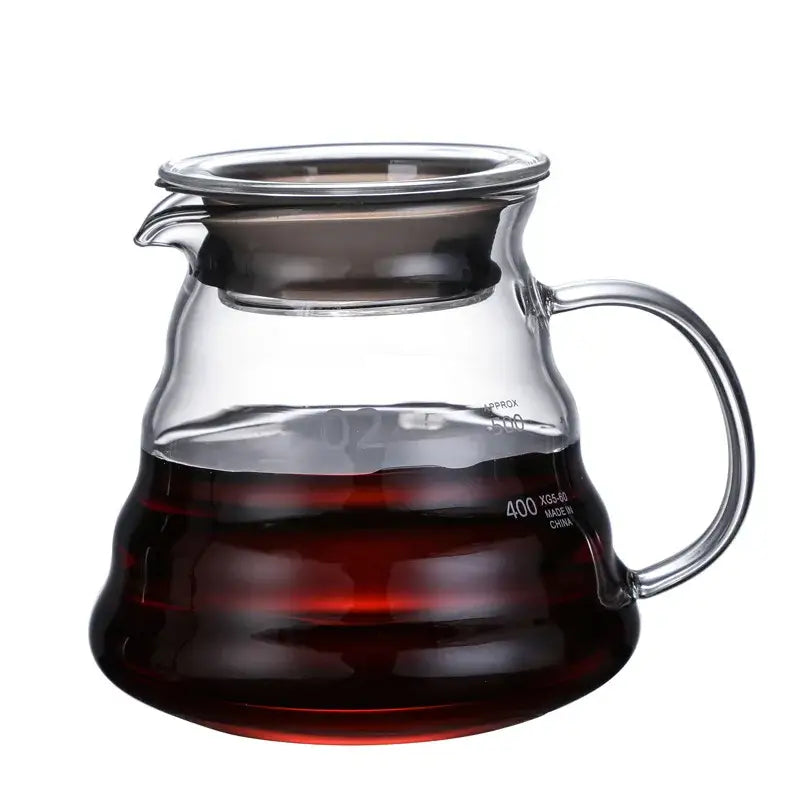 Clear glass ribbed coffee maker pot with curved handle and wood lid filled with dark brewed coffee for coffee brewing