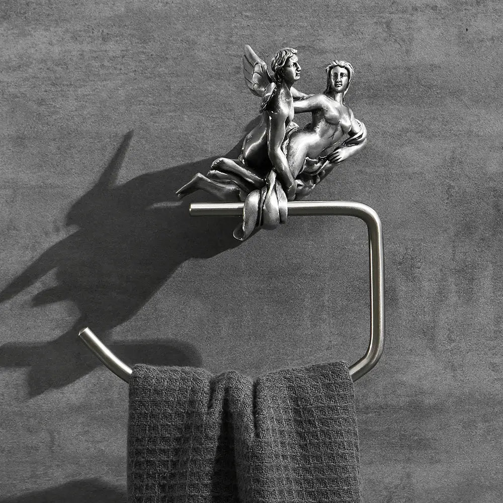 Silver-toned metal towel ring with ornate winged angel sculpture, part of a romantic silver bathroom hardware set
