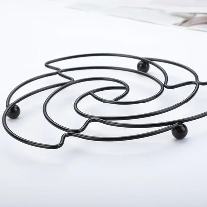 Black metal wire iron pan pot mat with spiral design and spherical feet for decorbites iron pan use