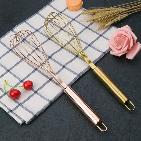 Two elegant rose gold and brass steel egg beaters with sleek handles and fine wire loops from decorbites gold steel set