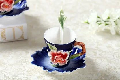 A delicate navy blue porcelain rose peony floral teacup with hand-painted pink peony on a leaf-shaped saucer