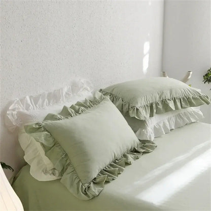 Soft sage green pillowcases with white ruffled edges in a light green egyptian cotton bedding set by decorbites