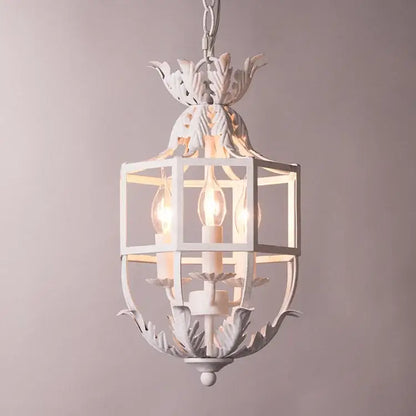 White wrought iron lantern with leafy accents and three exposed bulbs in decorbites grey gold metal cage chandelier design