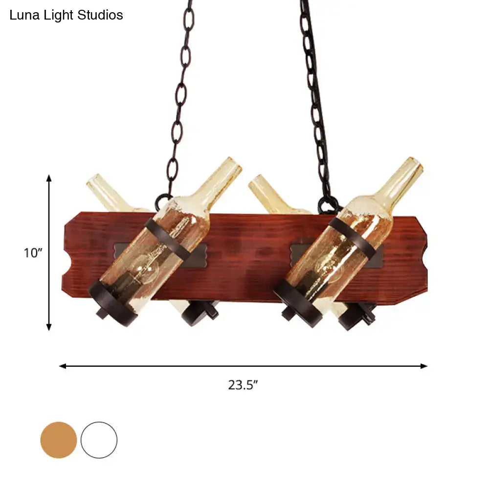Rustic island lamp with brown wood arm and frosted white two amber glass wine bottles suspended by dark chains