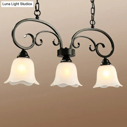 Black wrought iron chandelier with frosted white glass bell shades and black floral swirls ideal for restaurants