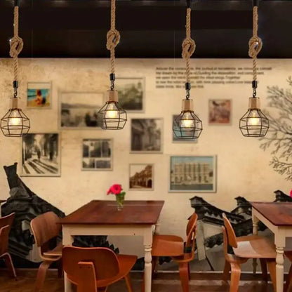 Rustic black iron pendant light with hemp rope cords and warm bulbs hanging in a dining room setting