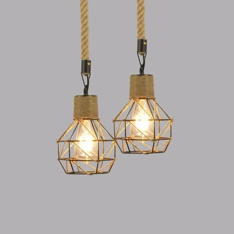 Two rustic black iron pendant lights with geometric wire cages and hemp rope cords for dining room use