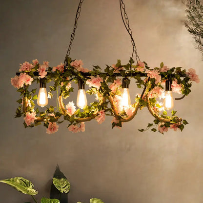 DecorBites™ black metal linear island lamp with four edison bulbs, pink artificial flowers, and green vines in lodge style