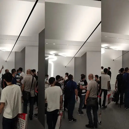 Crowd inside an apple store highlighting rustic black and white steel wall lamp strip for aisle brick decor