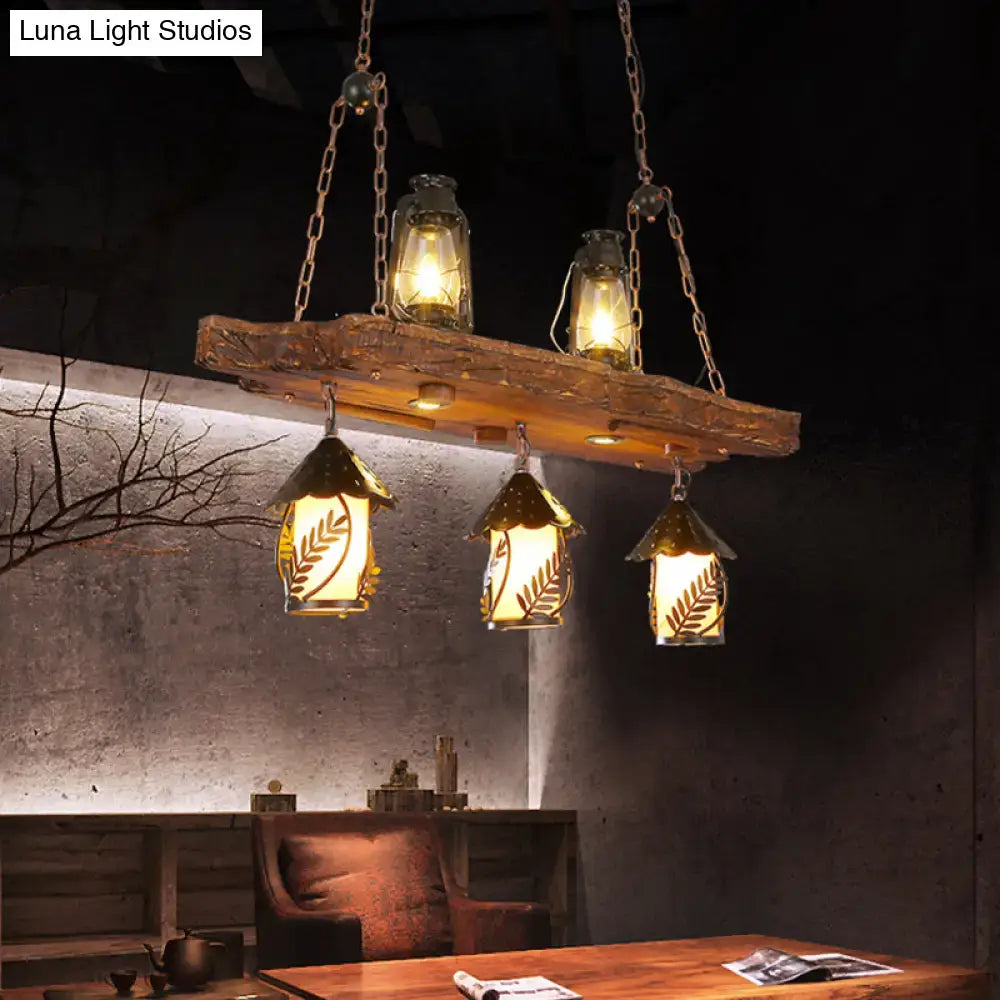 Rustic black wood lantern island ceiling light with hanging amber glass shades and leaf-patterned lantern design