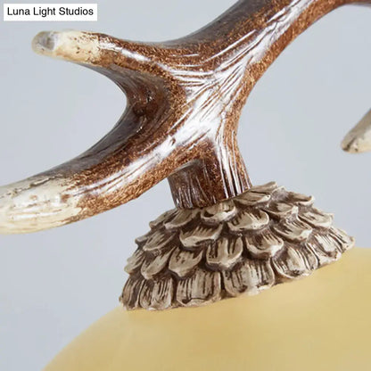 Antler-shaped distressed brown and cream lamp finial with ridges on bulb base of decorbites traditional ceiling light