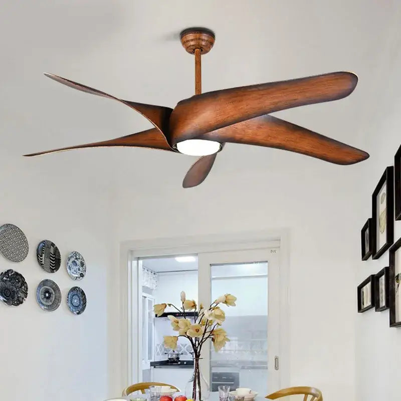A modern ceiling fan with five wide brown wooden blades and a central light fixture with remote control