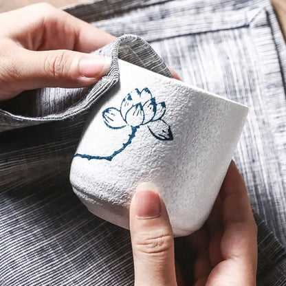 White coarse ceramic tea cup with textured surface and blue lotus design from decorbites rustic hand painted set