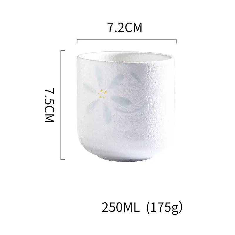 White ceramic tea cup with light blue floral design and subtle texture in decorbites coarse ceramic tea set