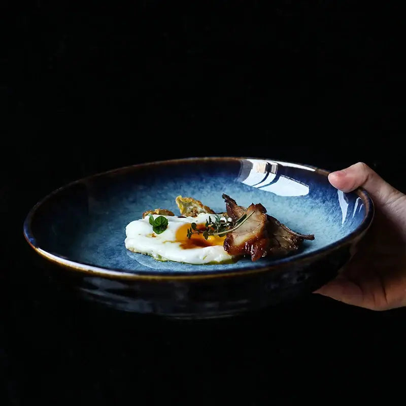 Rustic deep blue speckled ceramic salad bowl with dark brown rim holds sunny-side-up egg and seared meat by decorbites ceramic