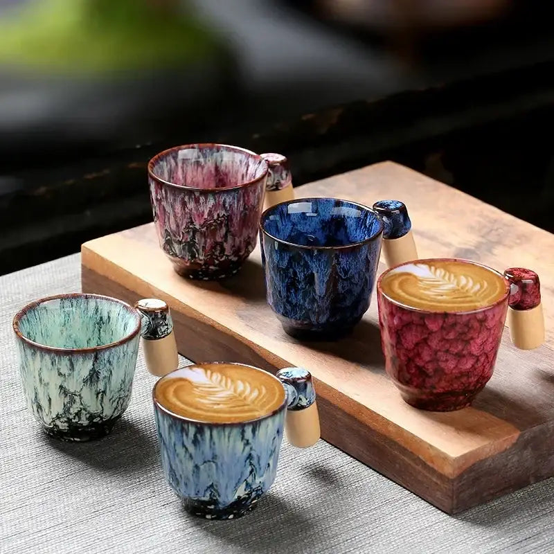 Rustic glazed ceramic latte mug with vibrant blue red and teal crackled glazes and a light wooden handle