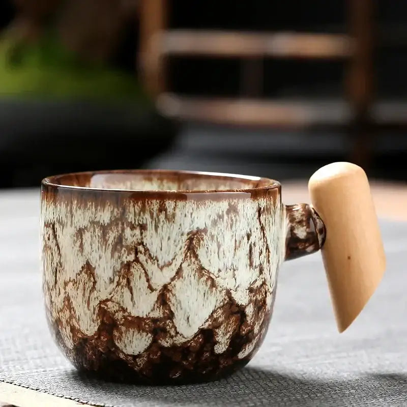 Rustic glazed ceramic latte mug with earthy brown and cream tones and a smooth wooden handle for kitchen use
