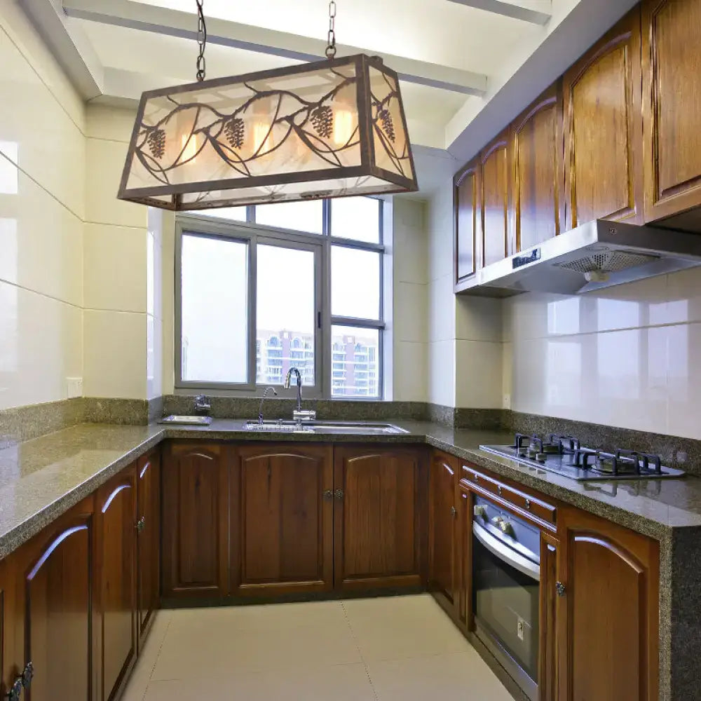 Rectangular rustic grapevine metal island light fixture with dark frame and warm glass panels for kitchen island light
