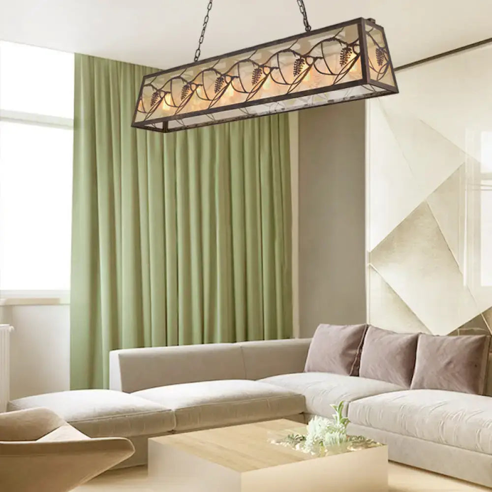 Rectangular rustic grapevine island light fixture with dark metal frame and leaf-patterned stained glass panels