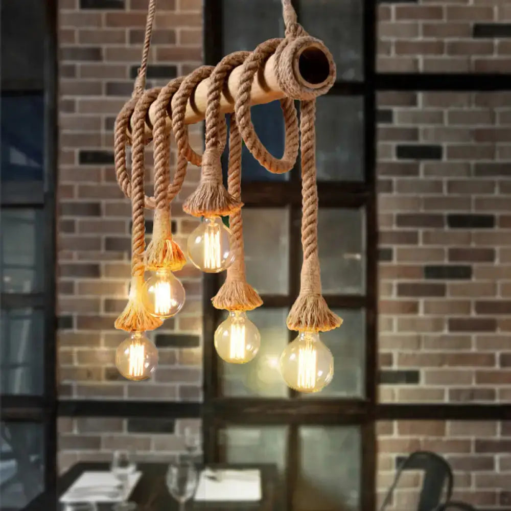 Rustic industrial island light with thick beige rope, wooden pipe, bamboo accents, and glowing filament bulbs by decorbites