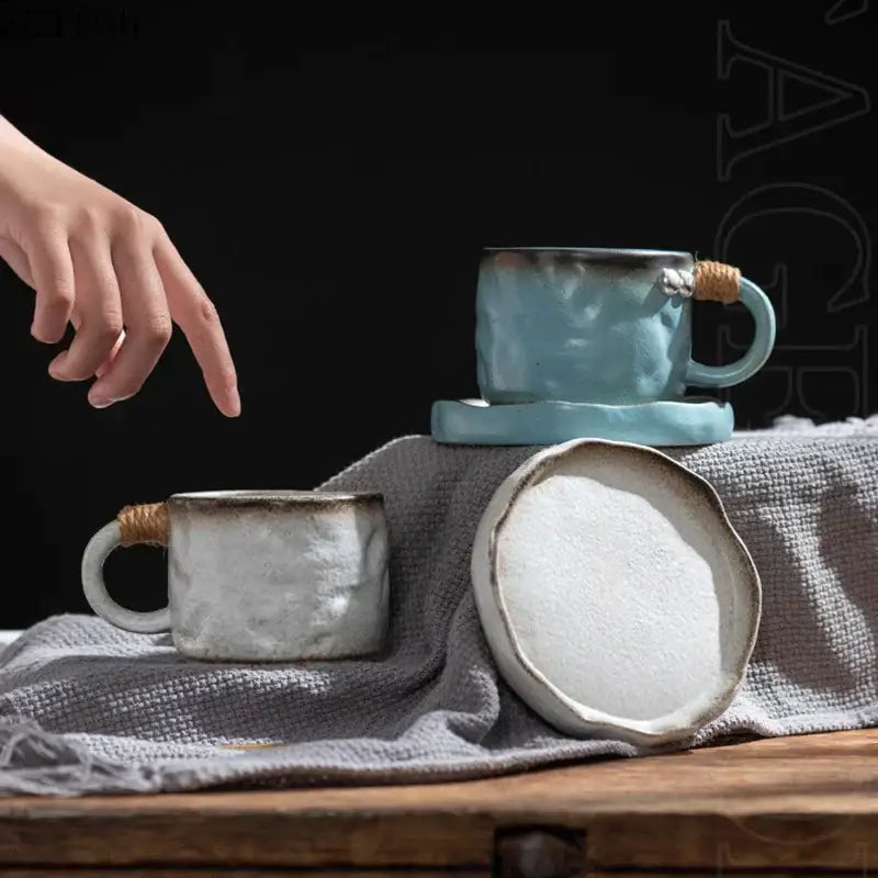 Rustic teal coarse pottery cup and saucer set with light blue and off-white decorbites coarse pottery mugs