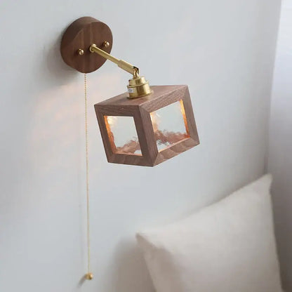 Rustic walnut and brass glass wall light fixture featuring a warm-toned wooden cube design for bedroom use