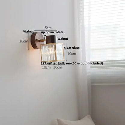 Rustic walnut and brass led wall lamp with a circular base and textured clear glass shade for bedroom lighting