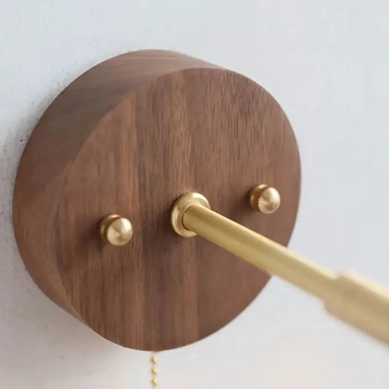A sleek circular walnut and brass led wall lamp with polished stem and finials for rustic dining room sconce lighting