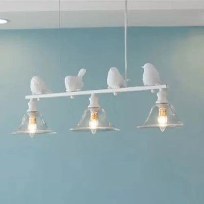 White bird-themed island light fixture with three clear glass shades and sculpted birds on a horizontal bar for balcony