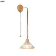 Rustic wall light with wooden base, brass metal arm, clear glass shade, and pull chain switch for easy use