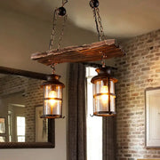 Rustic brown wooden plank pendant light with two clear glass lantern-style fixtures for clear glass island use