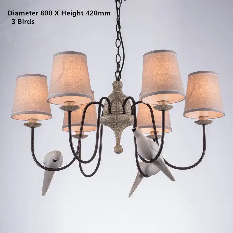 Antique-finished metal decorbites bird lamp chandelier with six beige fabric shades and three white ceramic birds