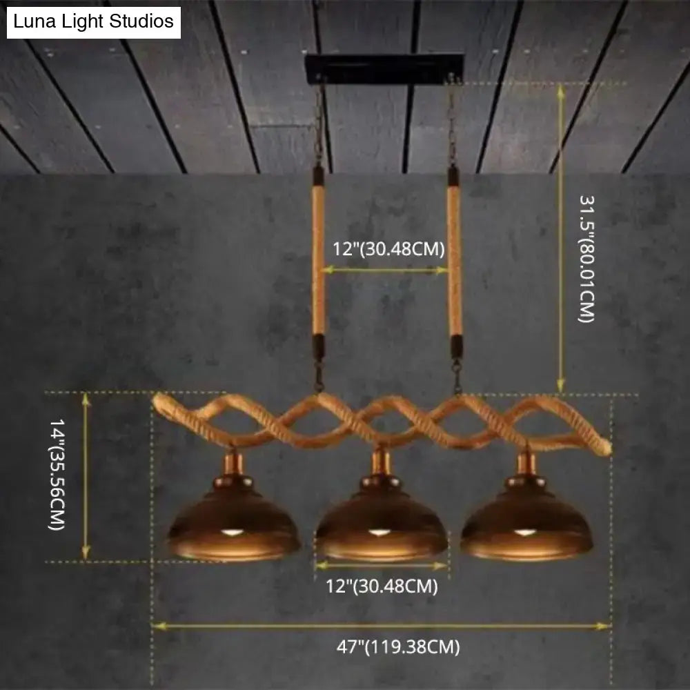 Industrial-style three-light pendant with copper dome shades and braided rope on rustic wooden beam for kitchen island lighting