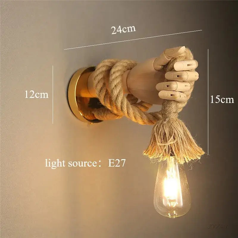 A rustic wall-mounted lamp featuring a wooden hand shape hemp rope holding an exposed filament bulb for restaurant corridors