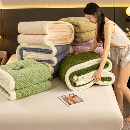 Stack of sage green and cream cozy warmth velvet autumn sleep blankets with plush textured fleece interior