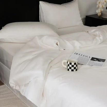 A white ceramic mug with a black and white checkered pattern next to a sage green double layer satin queen duvet set