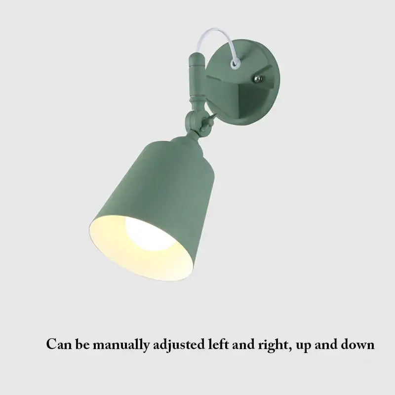 A matte sage green decorbites adjustable telescopic wall lamp with cylindrical shade and articulated arm for bedroom