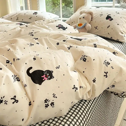 Sage green grid print cotton bedding set with cream duvet cover featuring a playful black cat and floral patterns