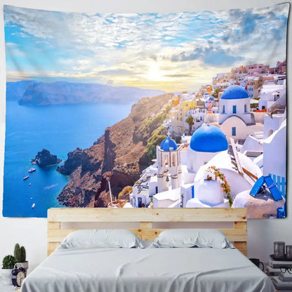 A vibrant blue and white Santorini castle village sunset tapestry hanging above a wooden bed frame