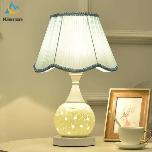 Cream-colored ceramic led desk lamp with scalloped light blue trim shade and floral cutout base for decorbites ceramic led