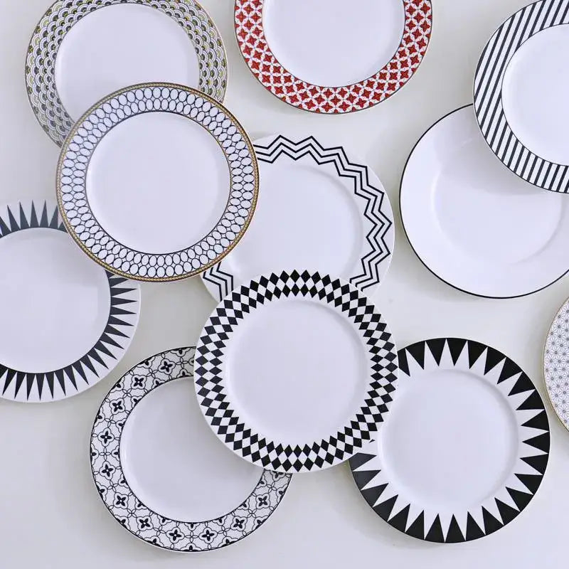 A collection of decorbites ceramic dessert plates with Scandinavian black and white geometric patterned rims in ceramic