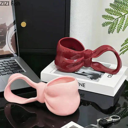 Glossy pink and red decorbites bowknot ceramic coffee mug with sculpted bow handle and reflective finish for kitchen use